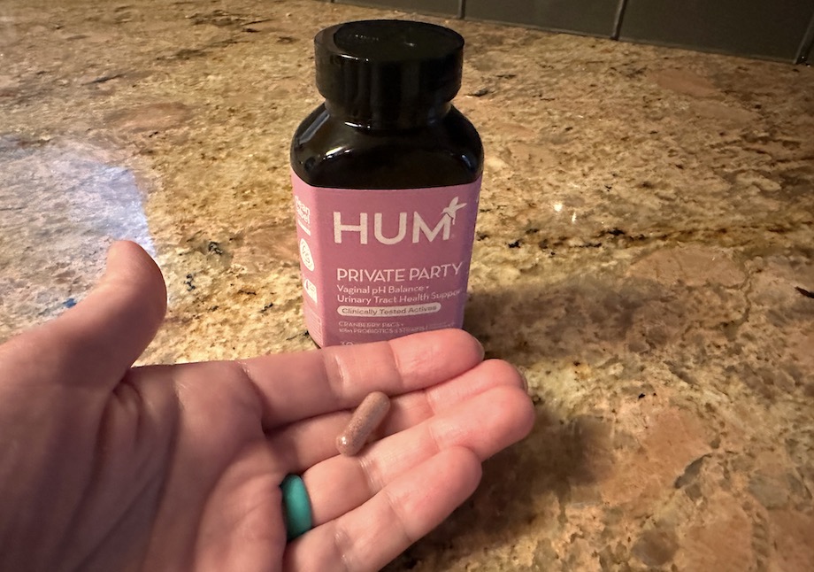 HUM Private Party Probiotic capsule in hand.